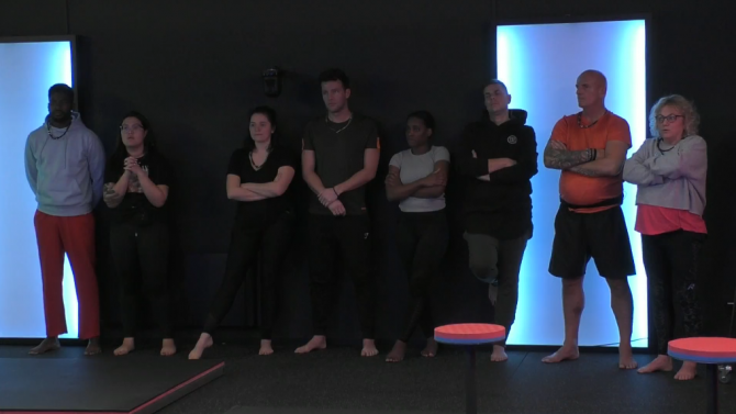 De bewoners doen een balanceer challenge in de gameroom